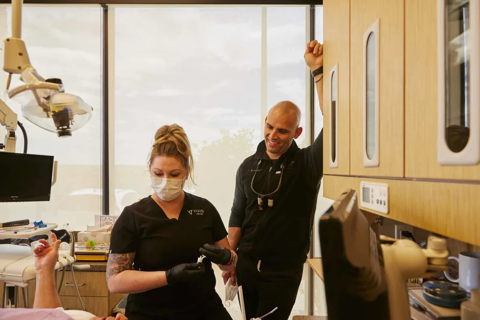 Dr Bryce Richardson and a dental hygienist speaking and smiling while talking to a patient
