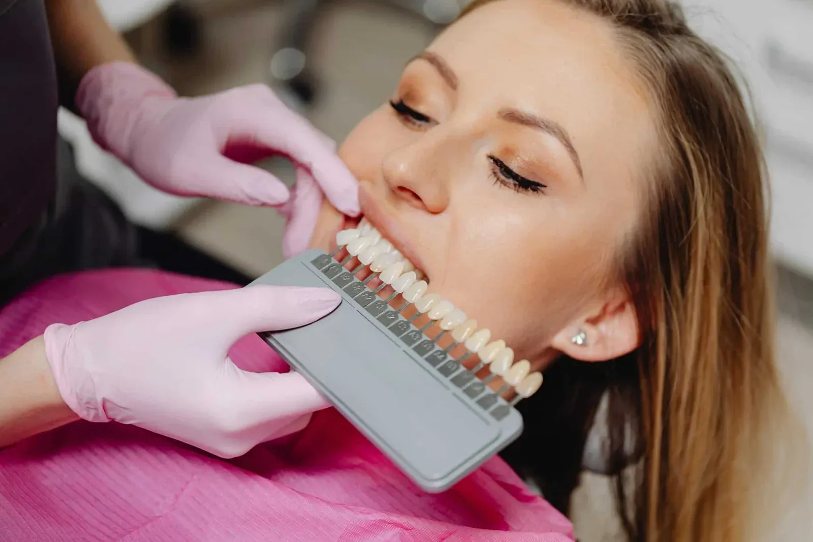 A patient during a veneer consult exampling different color options