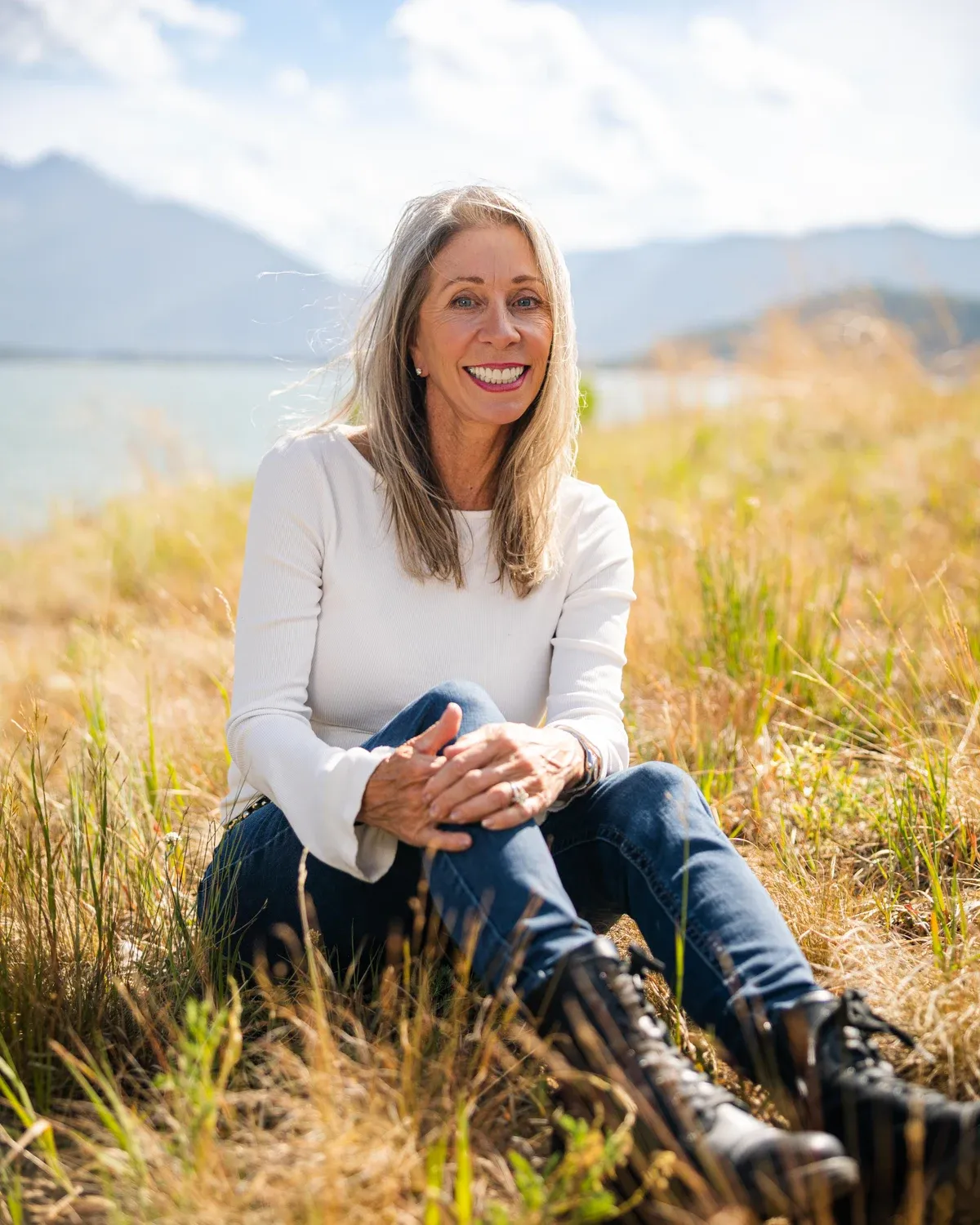 Woman seated in tall grass above a Colorado lake
