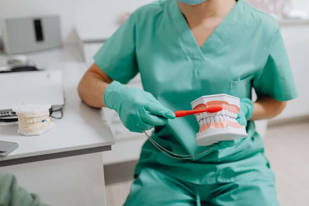 A dental hygienist showing proper teeth brushing techniques