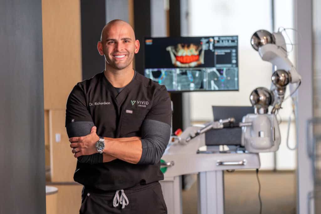 Dr Richardson in scrubs in-front of his dental equipment