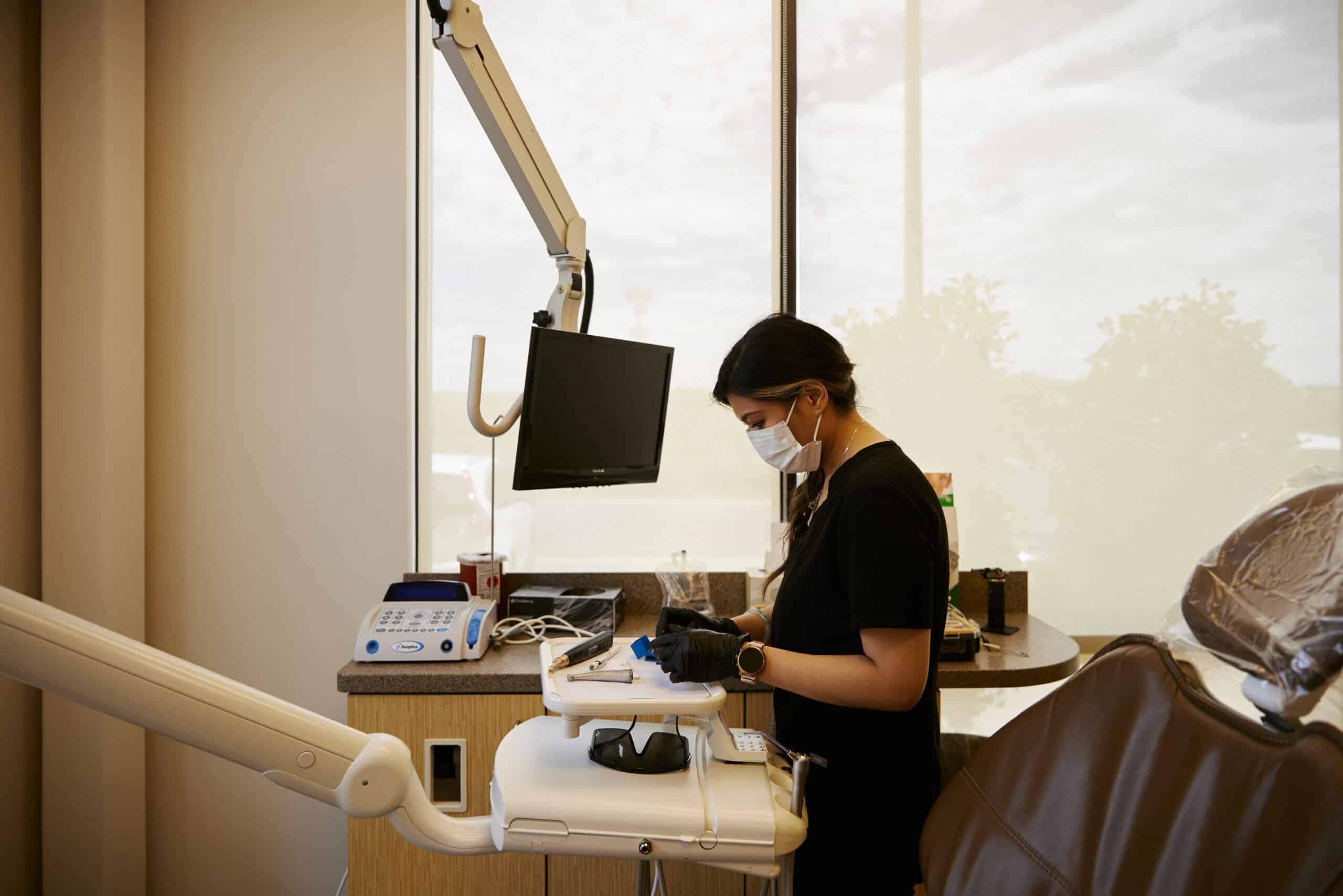 Dental hygenist preparing a room for a patient.