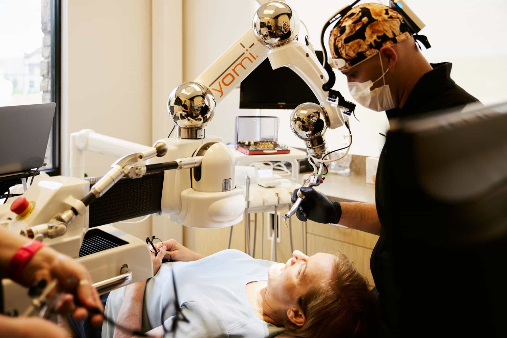 Dr Bryce Richardson using a yomi robot arm to preform a dental implant procedure
