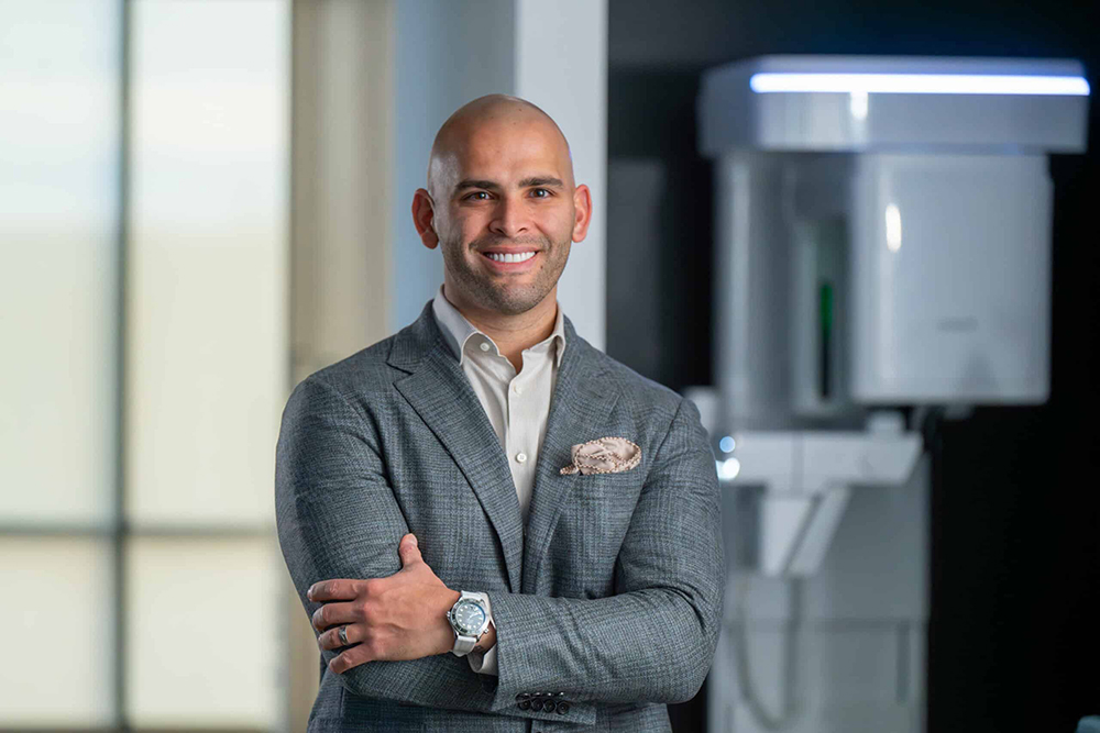 Dr Richardson in a suit in-front of dental equipment