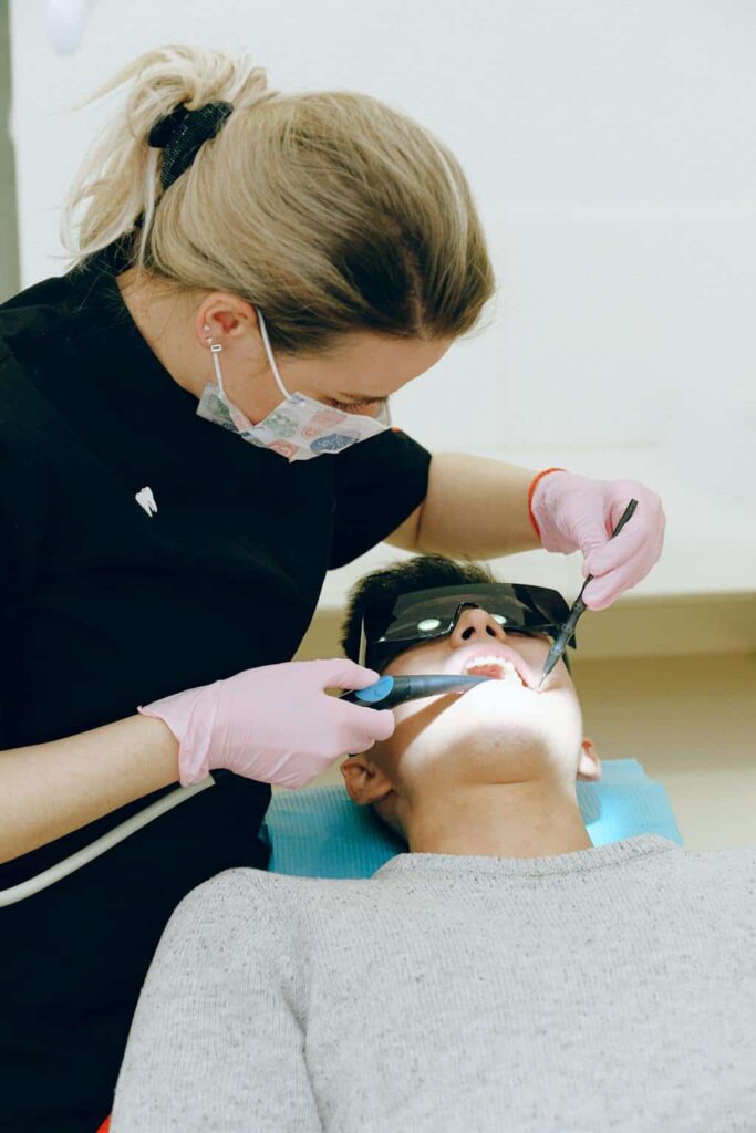 A dental hygienist preforming a dental cleaning