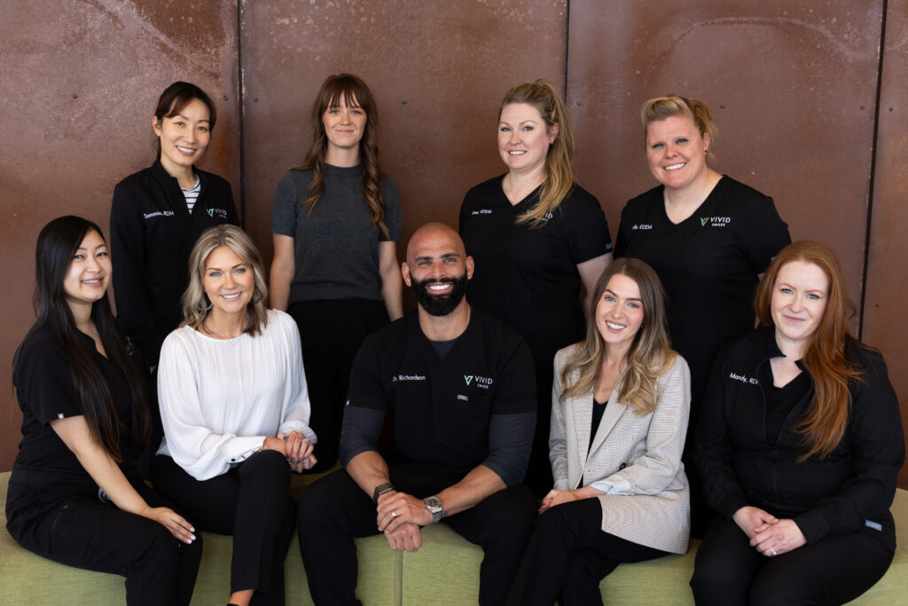 Group photo of the Vivid Smiles dental team sitting together outside the office.